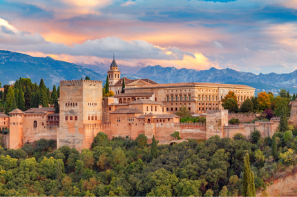 a large building with trees and mountains in the background with Alhambra in the background