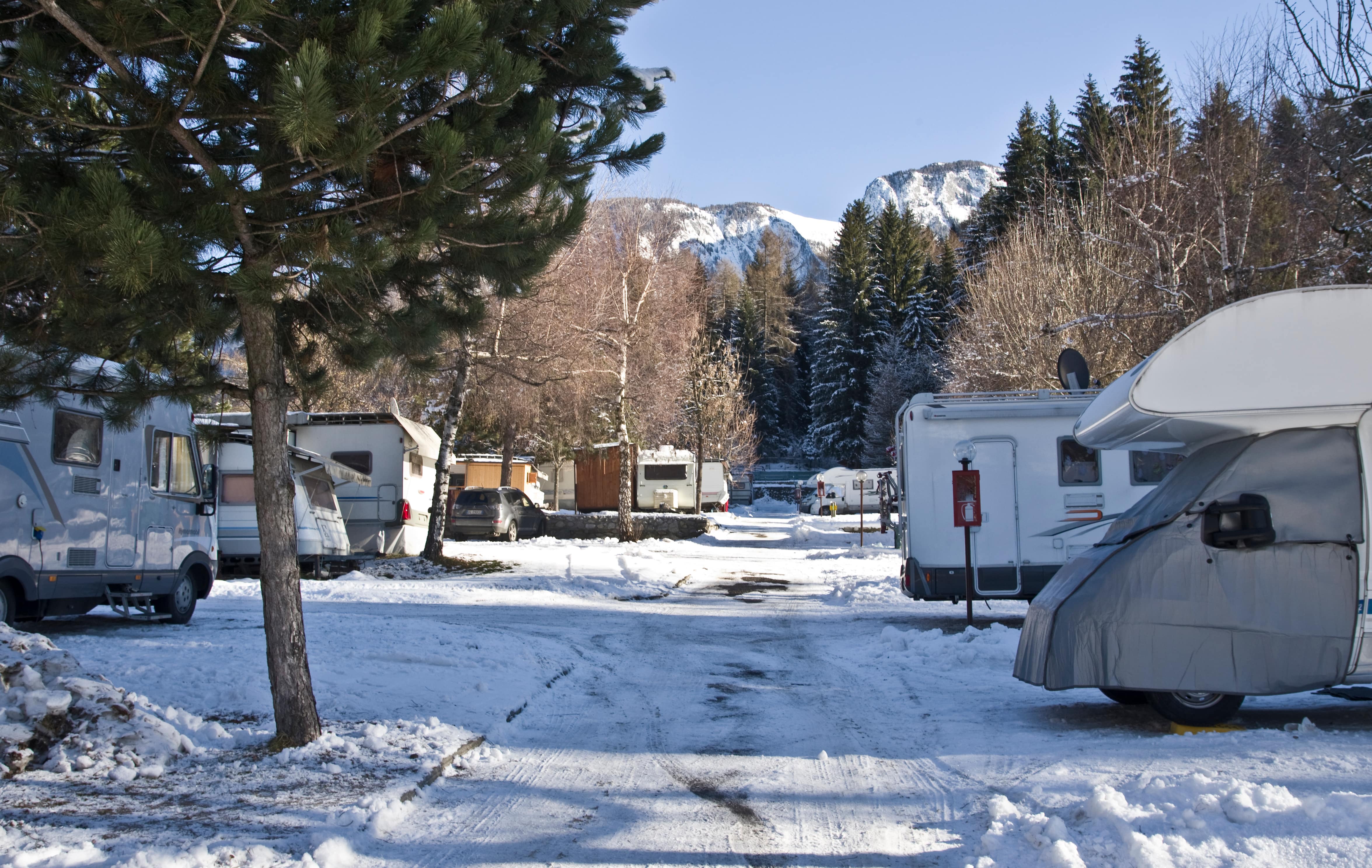 a group of rvs parked in a parking lot with snow