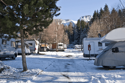 a group of rvs parked in a parking lot with snow