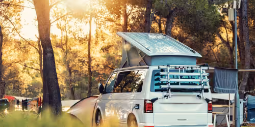 A white campervan parked in a forest